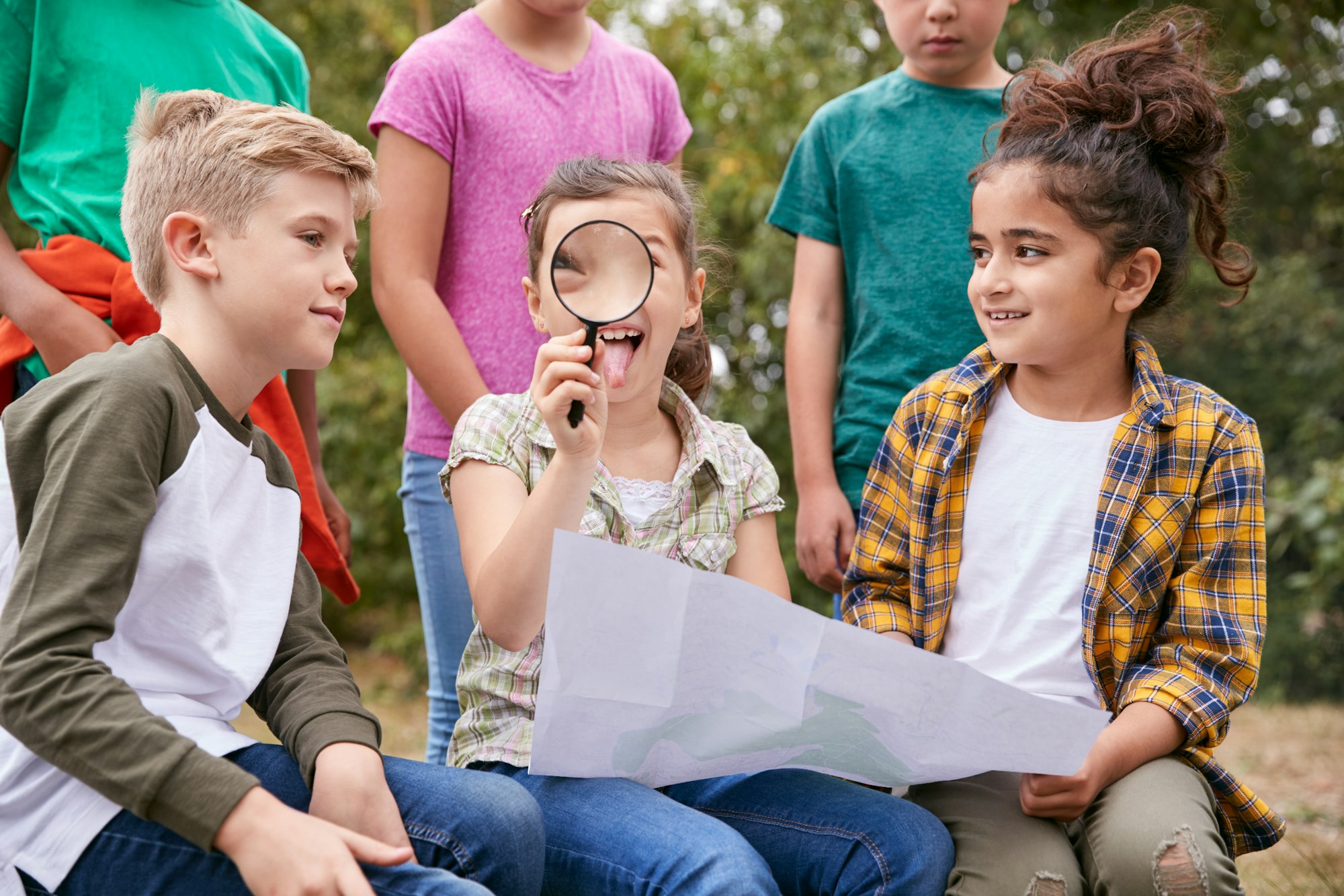 Group Of Children On Outdoor Activity Camping Trip Looking At Map Together