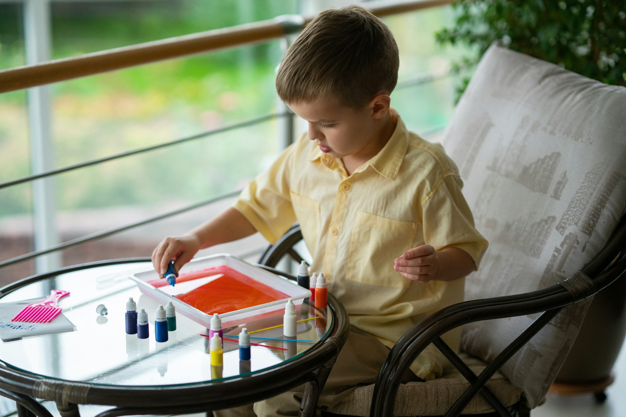 The boy draws with paints on the water.